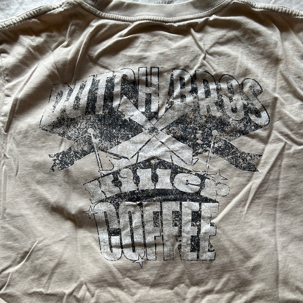 distressed looking cream colored dutch bros tee